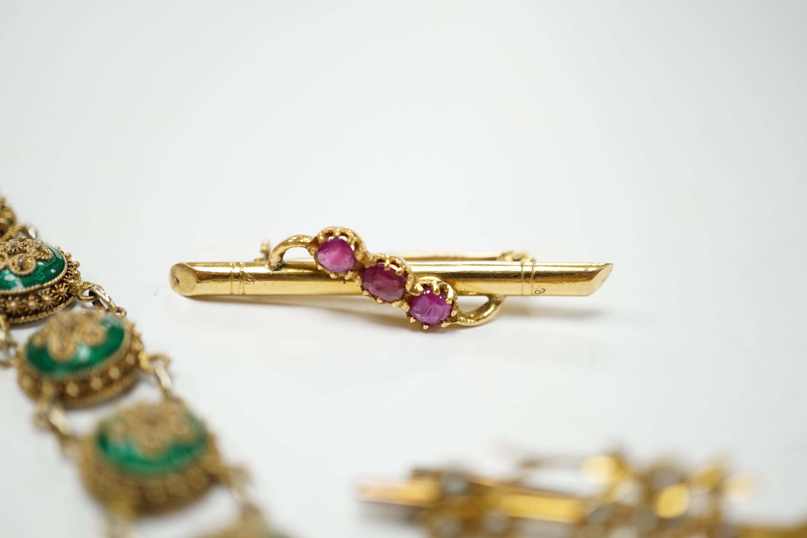 An Edwardian yellow metal, amethyst and split pearl set drop pendant, 52mm, on a yellow metal fine link chain, 45cm, a similar yellow metal and seed pearl set twin hearts bar brooch, a yellow metal and three stone ruby s